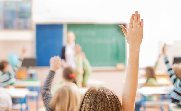 istock Children raising their hands in the classroom 180714399
