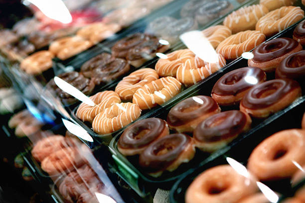 Different variations of sweet doughnuts arranged in a window display.