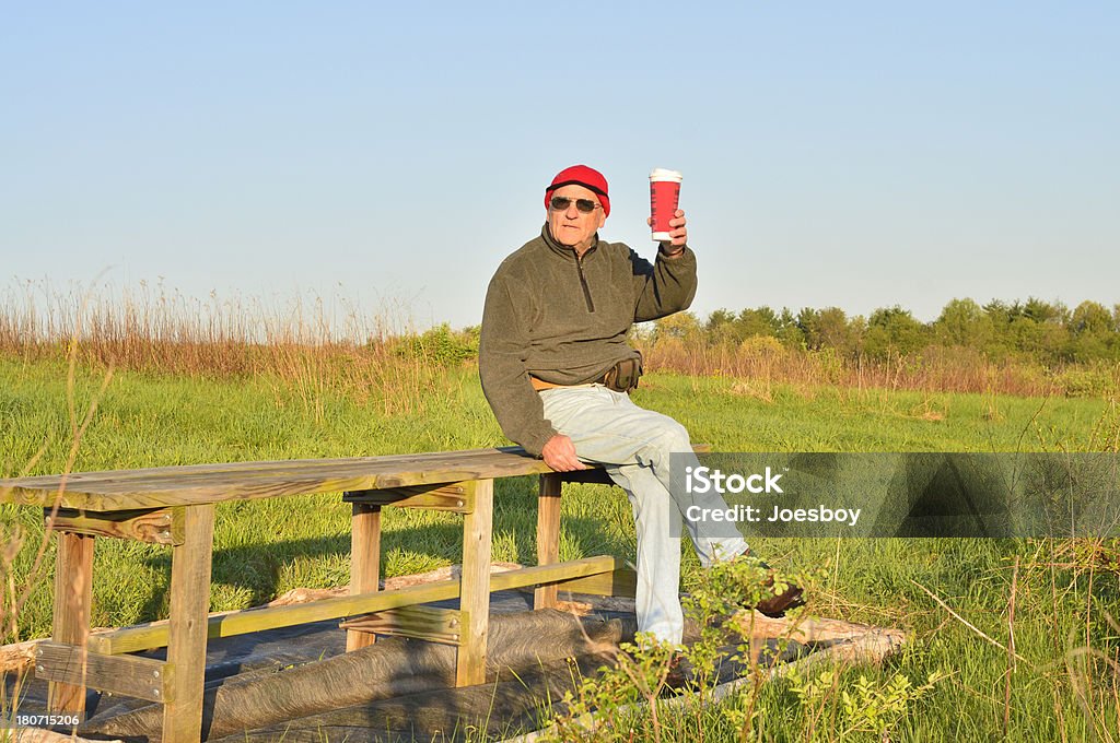 Hombre viejo sobre banco con café - Foto de stock de Brindar libre de derechos