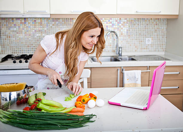 istock female cooking and looking up recepies online in kitchen 180715242