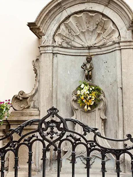 "Manneken Pis is a famous Brussels landmark, Belgium. It is a small bronze fountain sculpture showing a naked little boy urinating into the fountain's basin."