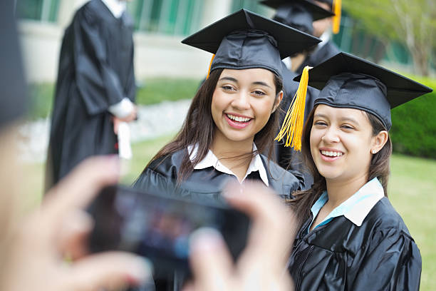 istock Friends smiling while having photo taken at graduation ceremony 180715713