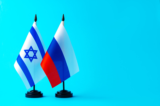 Flags of Russia and Israel on blue background in studio