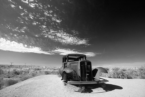 Rusty car in black and white on Route 66 in the Painted Desert National Park in Arizona United States