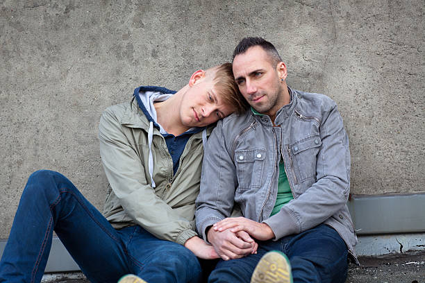istock two gay men sits front of a concrete wall 180716442