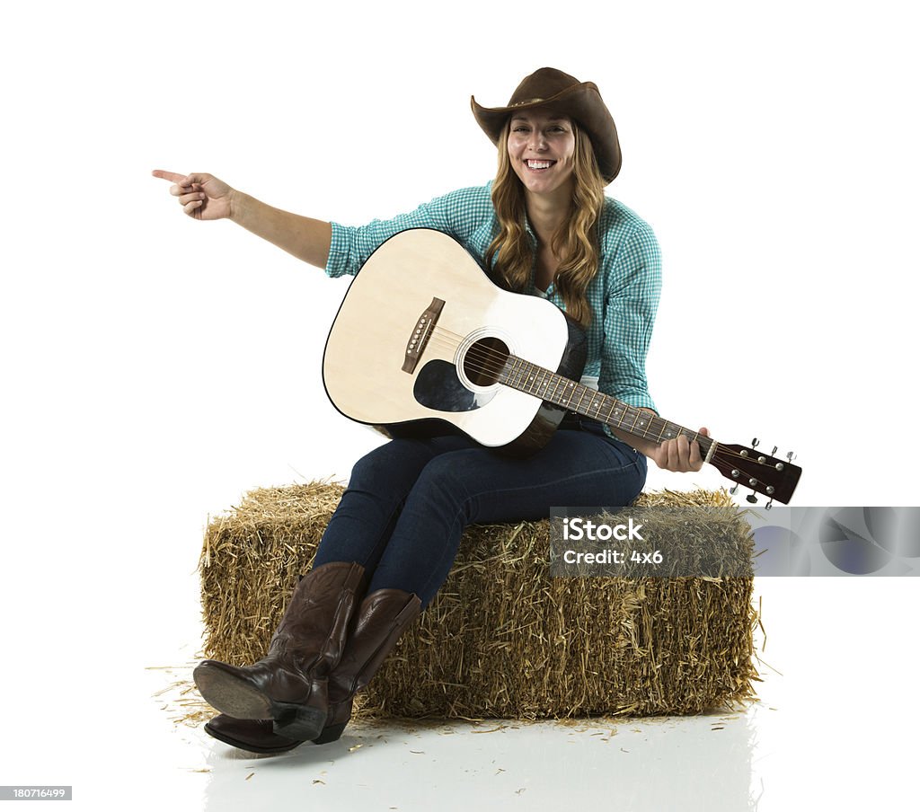 Cowgirl sitting on a hay stack and pointing Cowgirl sitting on a hay stack and pointinghttp://www.twodozendesign.info/i/1.png 20-29 Years Stock Photo