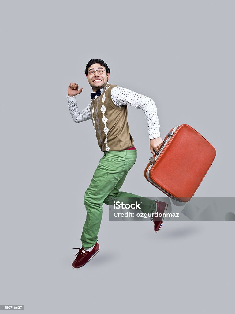 Nerd in air, holding suitcase "Nerdy young man in air, holding suitcase, smiling, portrait" Jumping Stock Photo