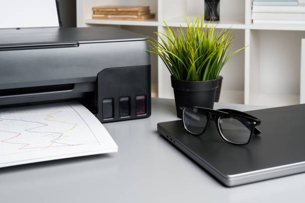 istock New modern printer and laptop in the office on table 1807168444