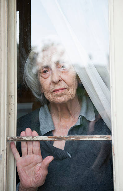 istock Senior Woman behind a window (Solitude) 180717009