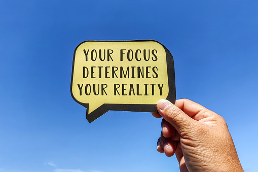 Your focus determines your reality word with speech bubble - Inspirational motivation quote.
