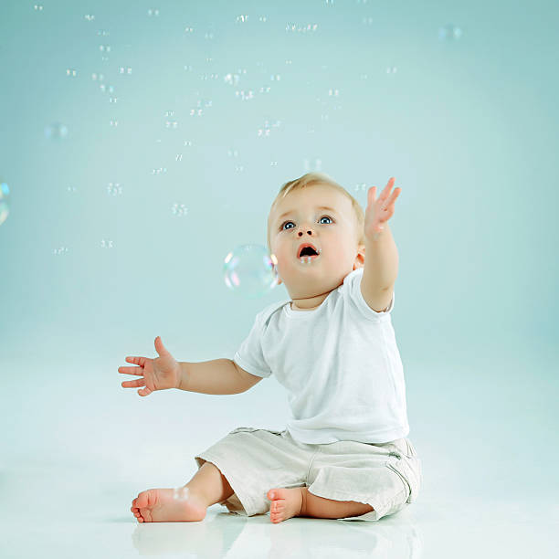 Little cute boy catching bubbles stock photo