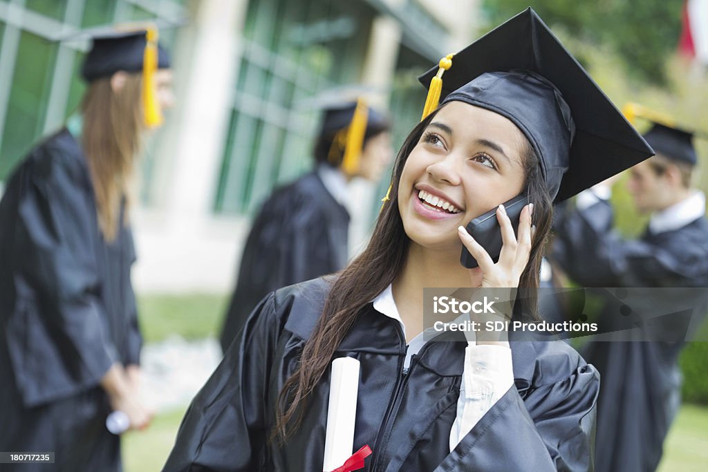 Pretty high school graduate llamar a alguien después de recibir su diploma - Foto de stock de Adulto libre de derechos