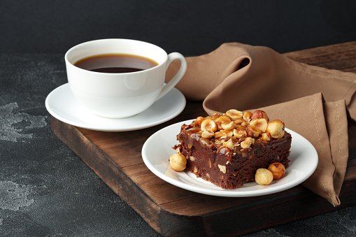Brownie cake with chocolate and hazelnuts on plate close up