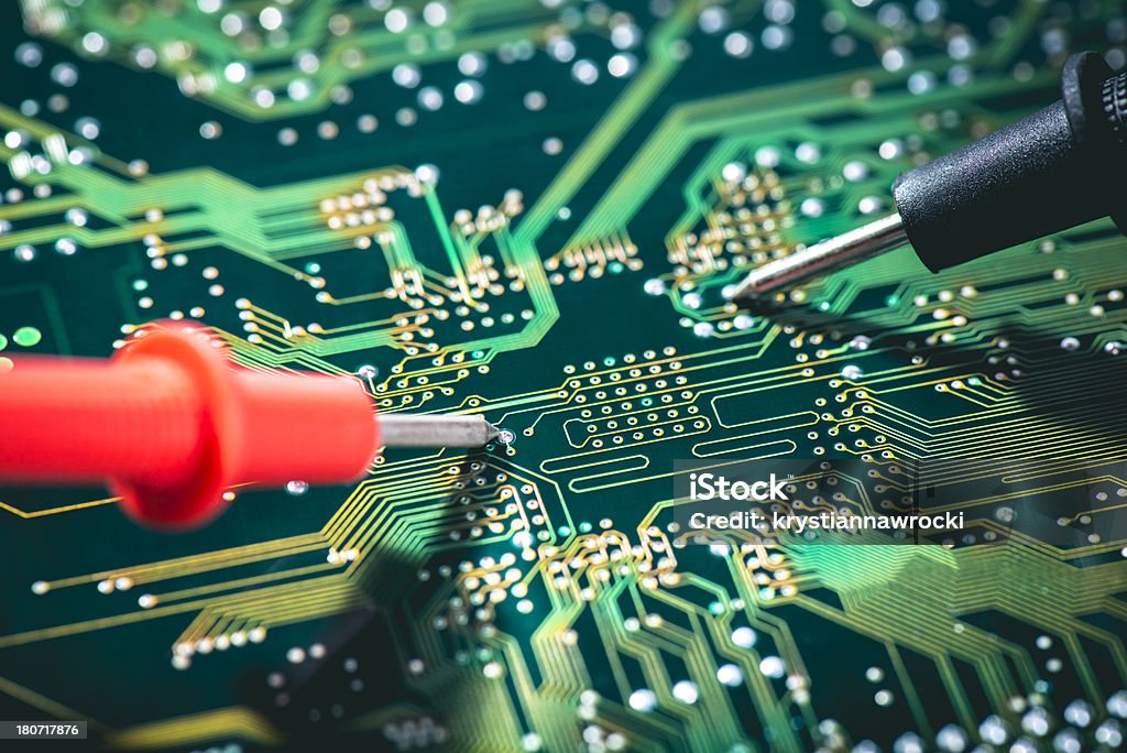 Technician checks circuit board Electronic technician checks the voltage on circuit boardMore in Analyzing Stock Photo