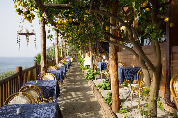 Amalfi Coast in Campania, Italy A restaurant under a lemon grove overlooking the Tyrrhenian Sea on the Amalfi Coast praiano photos stock pictures, royalty-free photos & images