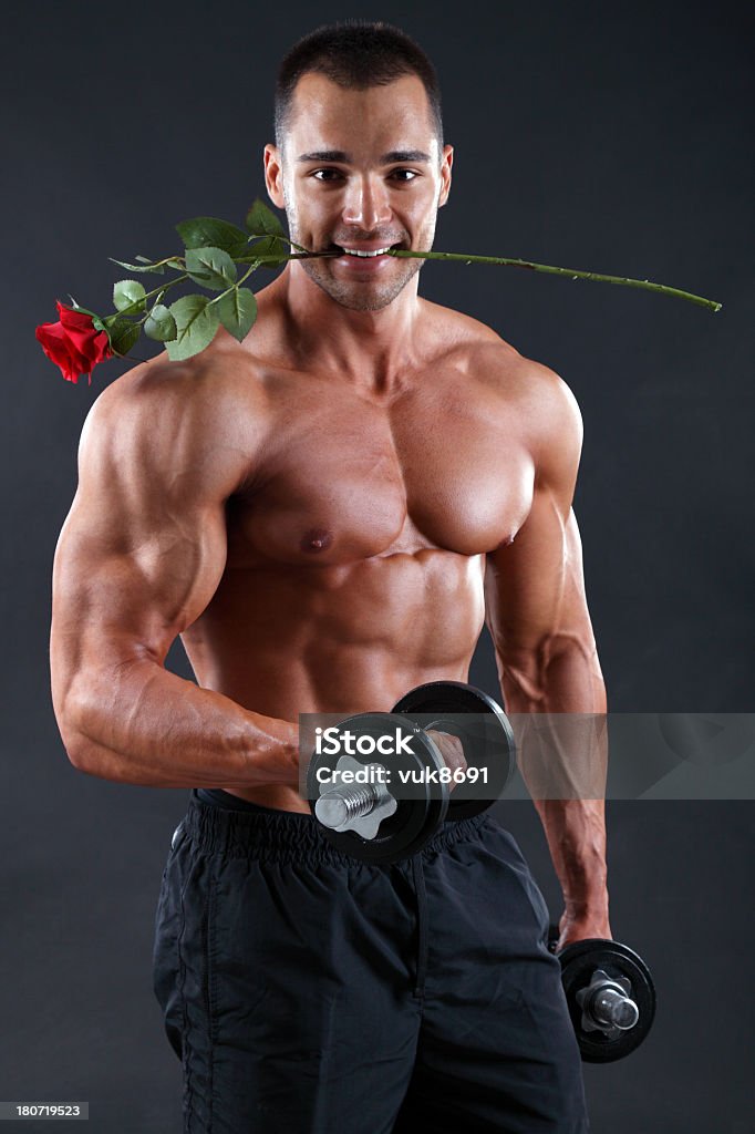 Bodybuilder con rosas rojas - Foto de stock de Abdomen libre de derechos