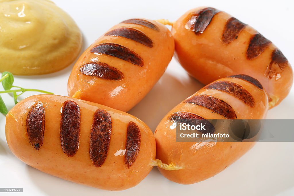 chain of grilled sausages chain of grilled sausages with mustard on a white background Barbecue - Meal Stock Photo