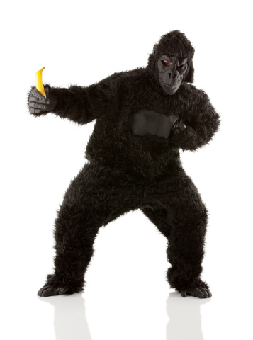 Man in gorilla costume holding banana