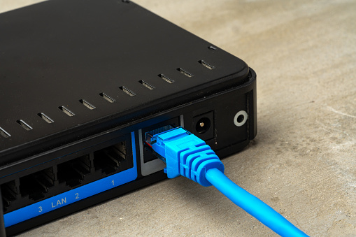 Modern router with cables plugged in close up photo