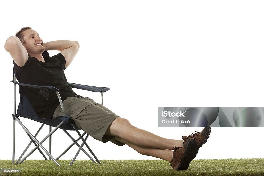 Man resting on chair in a lawn Sitting Stock Photo