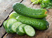 Cucumbers and slices on wooden table