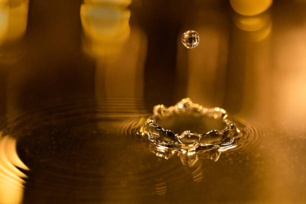 istock Golden liquid background with reflection of lights and water drops 180720419
