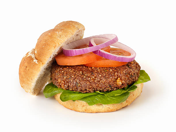 Quinoa Burger "A fantastic vegetarian burger made with quinoa, chick peas, rolled oats, crushed onions and garlic, spices on a Whole Wheat Bun with spinach, tomatoes and onion -Photographed on Hasselblad H3D2-39mb Camera" veggie burger photos stock pictures, royalty-free photos & images
