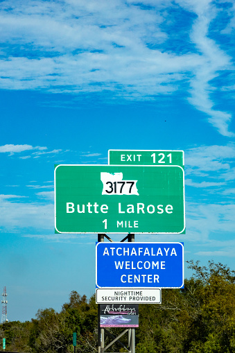 Atchafalaya, USA - October 23, 2023: sign Atchafalaya welcome center in one mile at the highway with provided nighttime security and alligator on signage, Louisiana