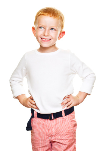 Portrait of cute little boy standing with hands on hip and laughing. Studio shot, isolated on white.
