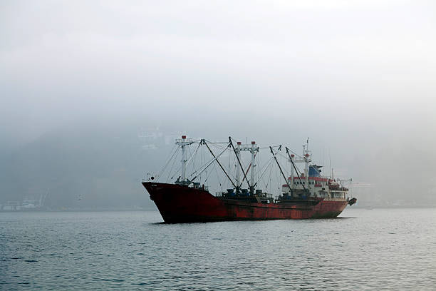 Small Blue Fish Trawler Fishing In The North Sea On A Hazy And Sunny Summer Day