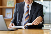 Asian businessman reading at a cafe to study