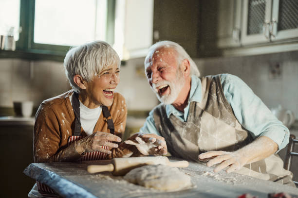 istock Cheerful mature couple having fun while making a cake in the kitchen. 1807233128