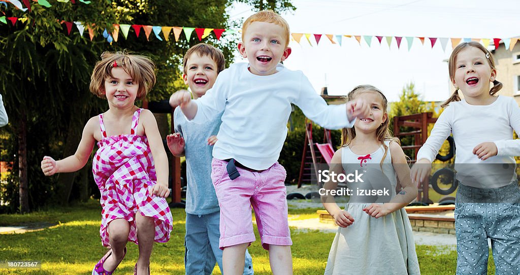 Kids Jumping Outside Five preschool kids jumping in the playground. 4-5 Years Stock Photo