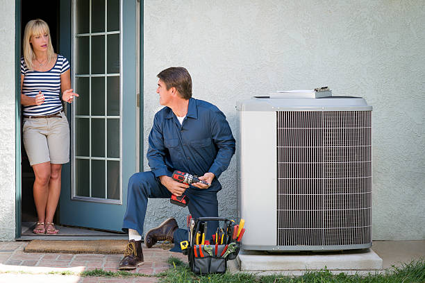 Air Conditioner Repairman "Air conditioner repairman in uniform, discussing with the female homeowner the unit's repair.Take a look at my LIGHTBOXS with other related images." door repairman men manual worker stock pictures, royalty-free photos & images