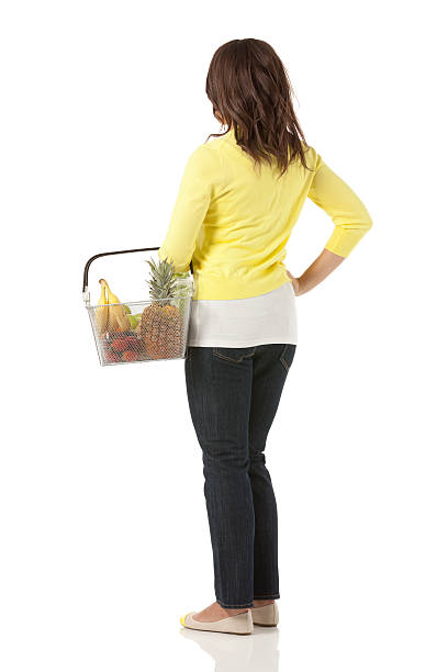 mujer llevando una canasta de frutas - isolated on white full length lifestyles yellow fotografías e imágenes de stock