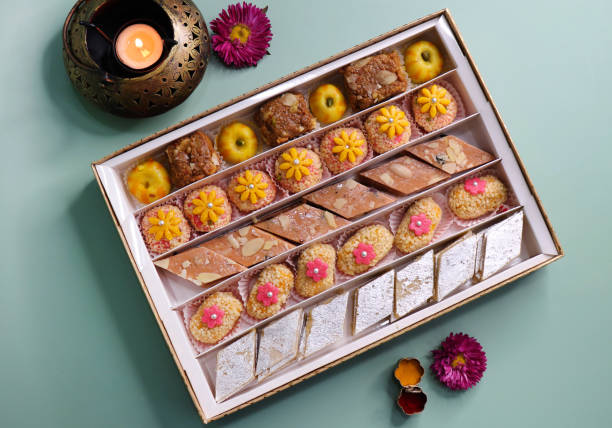 istock Indian assorted Diwali sweets or mithai box with diya and flowers. Festive gift idea. Kaju katli, dry fruits peda, barfi, cashew nut barfi, marzipan, khoya cakes. christmas box. copy space. 1807239361