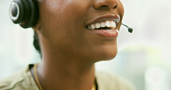Woman, mouth and headphones in call center for customer service, telemarketing or support at office. Closeup of female person, consultant or agent smile with mic in online advice or help at workplace