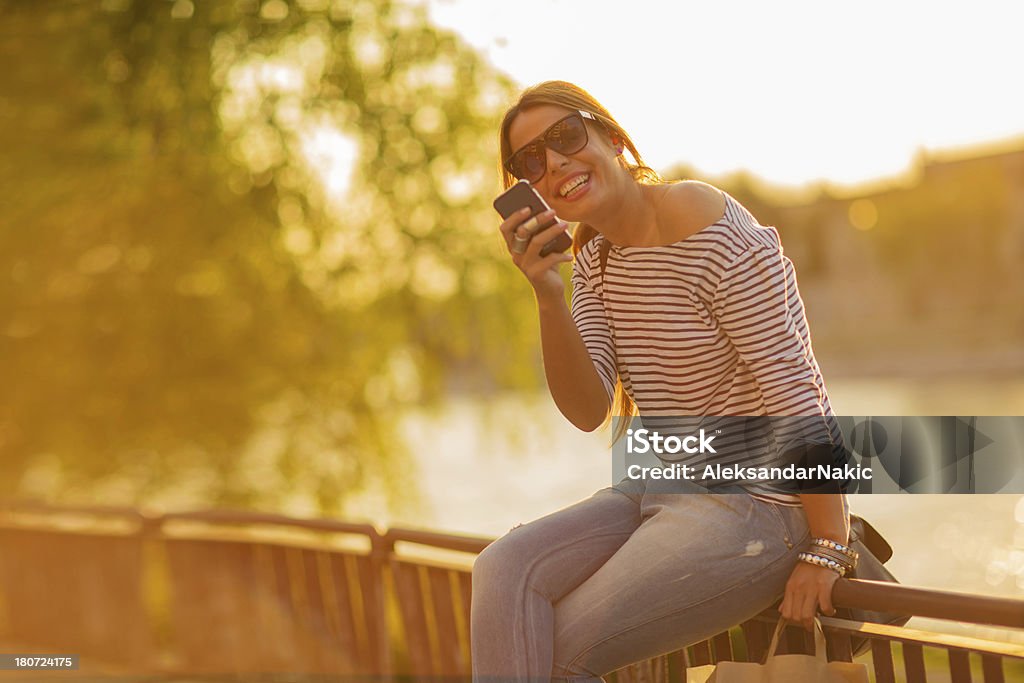 Lächelnde Junge Frau mit einem smartphone im Freien - Lizenzfrei Cool und Lässig Stock-Foto