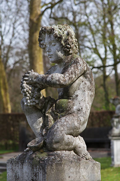 istock Old weathered statue of cherub with grapes 180724636