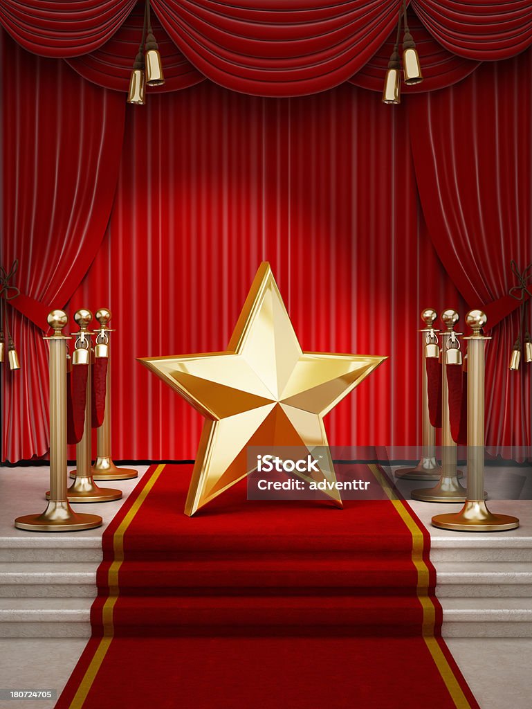 Red carpet star Gold star shape standing on the podium at the end of the red carpet and pole barriers. Red Carpet Event Stock Photo