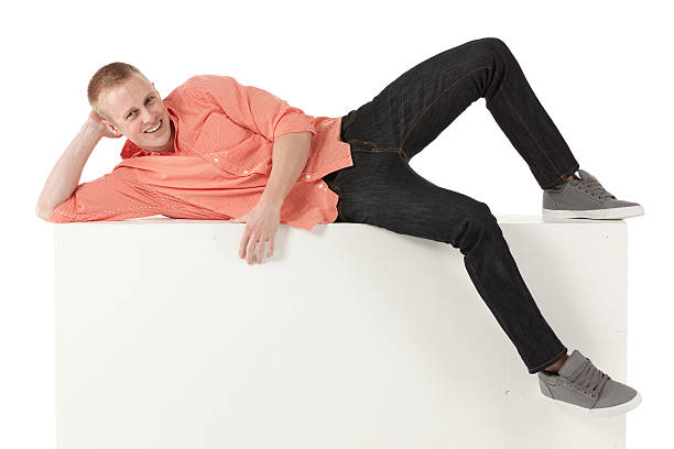 istock Happy young man lying on the ledge of a wall 180724739