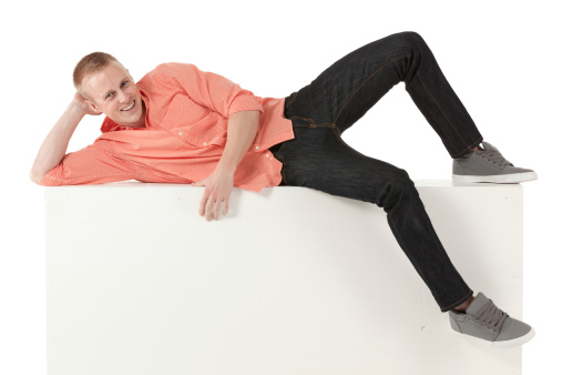 Happy young man lying on the ledge of a wallhttp://www.twodozendesign.info/i/1.png