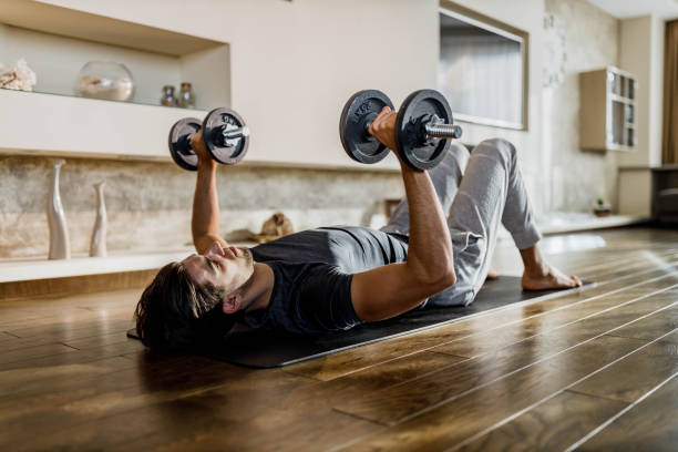 istock Muscular build man exercising strength with weights on a floor. 1807248925
