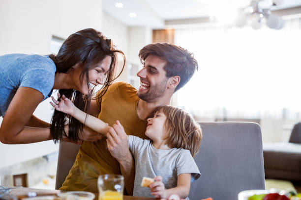 istock Young happy family having fun during breakfast in dining room. 1807250565