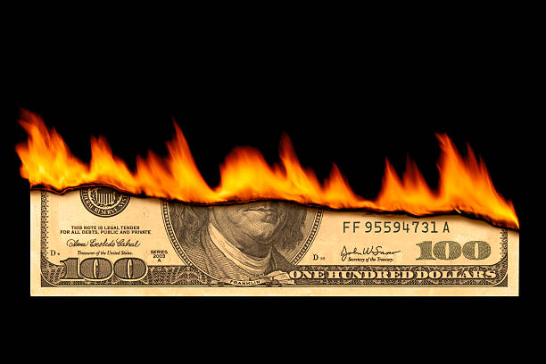 istock One hundred dollar bill on fire on black background 180725117