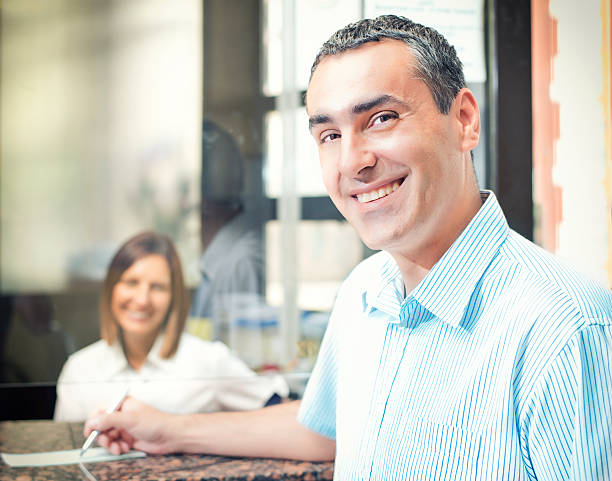 escribiendo un verificación - bank bank teller customer banking fotografías e imágenes de stock