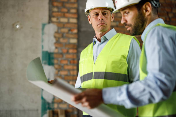 istock Civil engineers working on blueprints at construction site. 1807253860