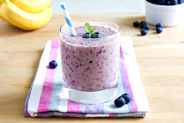 blaubeer-bananen-smoothie - blueberry smoothie glass striped stock-fotos und bilder