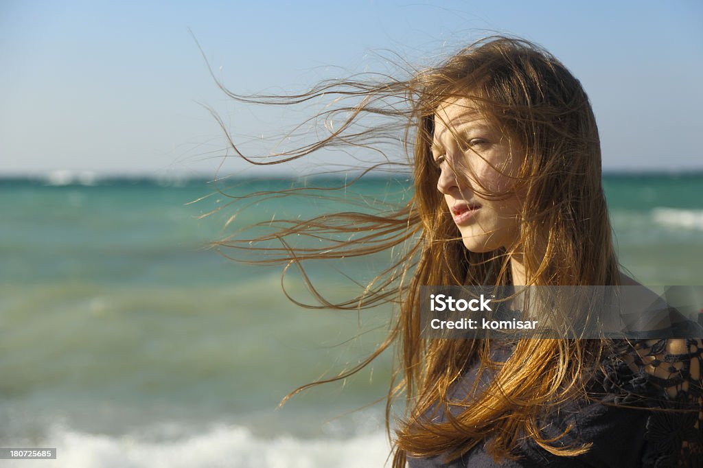 Ragazza con capelli lunghi sulla costa - Foto stock royalty-free di Donne
