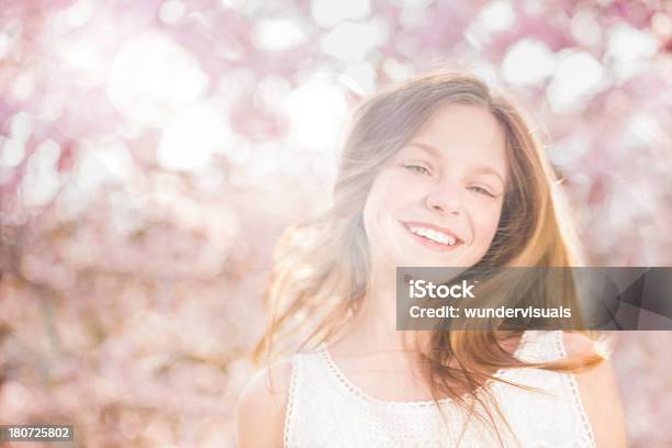 Sonriente Niña Mirando A Cámara Durante La Primavera Foto de stock y más banco de imágenes de Adolescencia